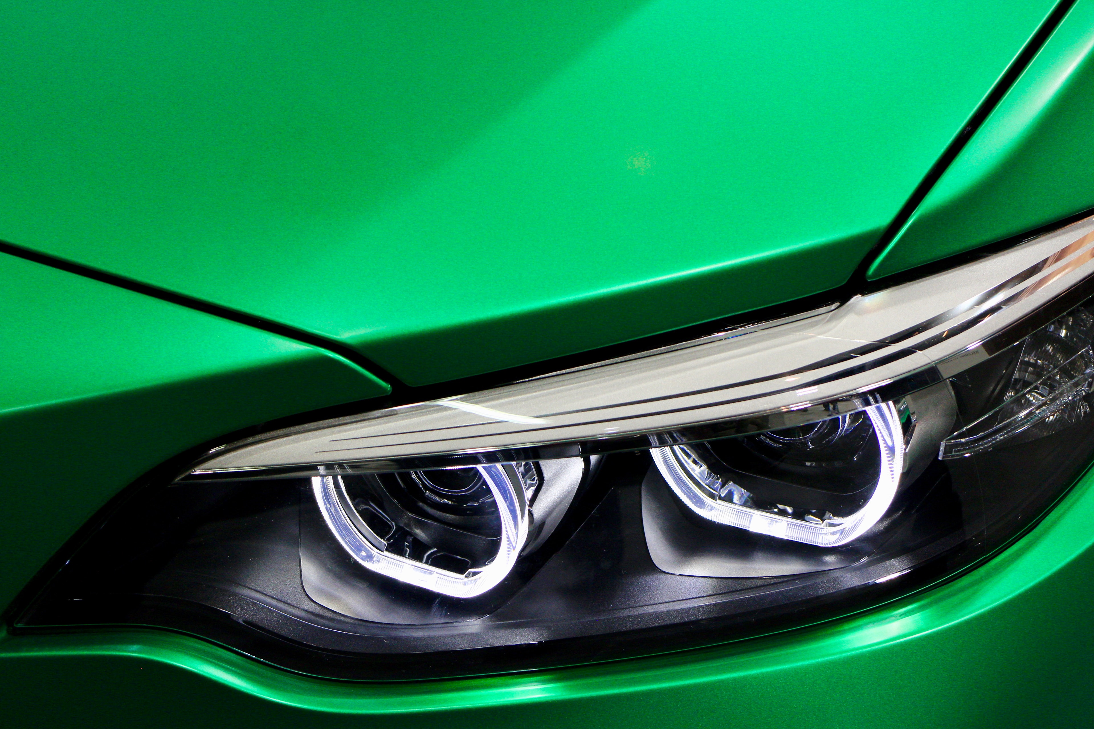linker koplamp van een BMW met een opvallend mooie
							     groen-metallische lak; Teaser:
							     aandachtige demontage- en montagewerkzaamheden voor ecologisch en
							     milieuvriendelijk waardeherstel van autos door Teamwise.